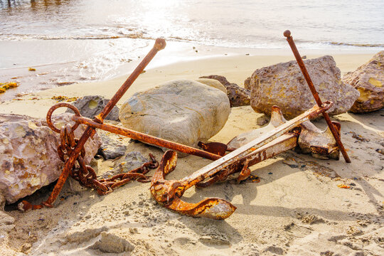 Rusty Anchors and Chains on Sandy Beach