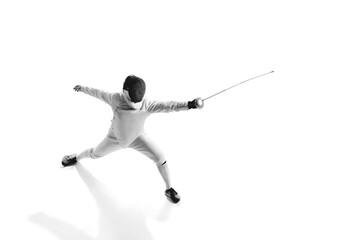 Dynamic portrait of male athlete in fencing costume with sword in hand in action isolated on white studio background.