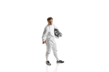 Young man, male fencer in fencing costume mask standing with sword over white studio background....