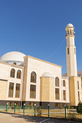 Obraz premium White Muslim Mosque and minaret against the blue sky in the mountains of Dagestan. Symbol of Islam and Ramadan. vertical