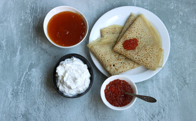 Shrove Tuesday celebration. Tiny Crepes on a plate. Festive food close up photo. 