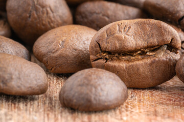 Obraz premium Close up of coffee beans on wooden background. Fresh coffee beans, macro shot