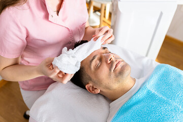 Fototapeta na wymiar Beautician doing face treatment in beauty salon to a man.