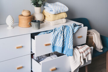 white scandi drawer with messy knitted sweaters. Spring home cleaning and wardrobe organization....