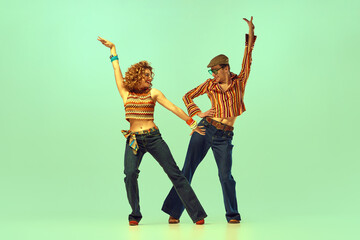 Incendiary dance. Emotional man and woman in retro style clothes dancing disco dance over green...