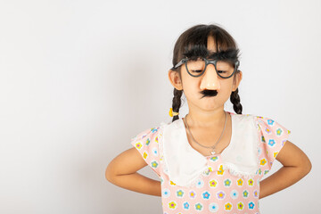 April Fool's Day. Portrait of Funny kid little girl clown wears a big nos and glasses and has a mustache isolated on white background with copy space, Happy smile child festive decor