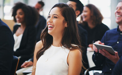 Opening the presentation with some in house humour. Shot of a happy young businesswoman sitting in...