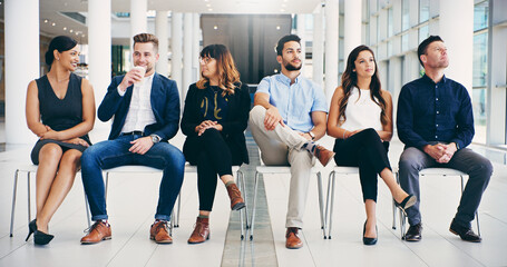 New places, new faces. Shot of a group of diverse businesspeople waiting in line in a modern office.