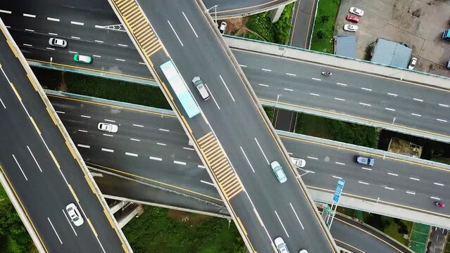 Aerial cenital shot of circular roads and highways floating five levels exchange in Chongqing and cars driving on them, Huangjuewan exchange.