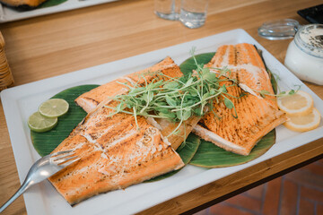 Grilled salmon steak on white plate with lime and herbs, stock photo. Healthy food on the table. Healthy food concept. Soft focus.