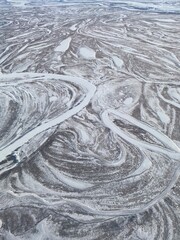 Abstract winter panorama with snow-covered territory - forests, fields and winding rivers.