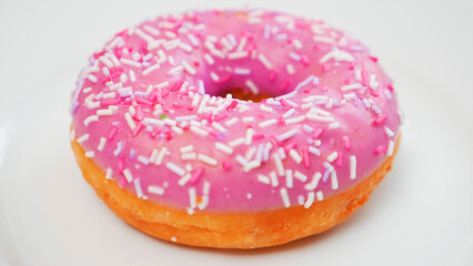 Donut with sprinkles on a white plate