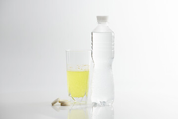 The effervescent tablet dissolves in a glass of water.