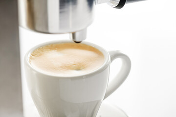 A cup of freshly brewed aromatic espresso on a white background.
