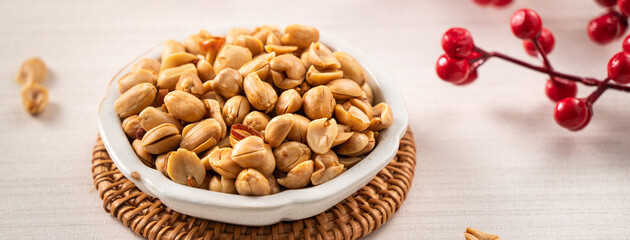 Spicy flavored peanut kernel in a bowl on white table background.