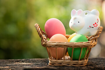 Easter eggs and ceramic rabbit on nature boken background.