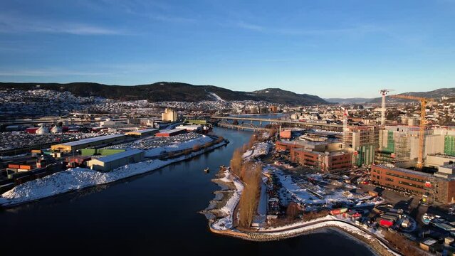 Aerial drone view of Port of Drammen and large construction area  separated by the river in a clear winter day.