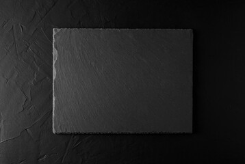 Black granite stone board on black concrete background