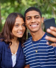 Fototapeta premium Living life one snap shot at a time. Shot of a young couple taking a selfie outside.