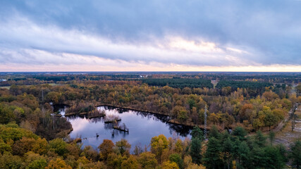 Naklejka na ściany i meble Moody sunset clouds over a forest in the fall. High quality photo