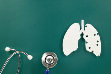 World Tuberculosis Day. Top view of lungs paper symbol and medical stethoscope on green background,...