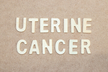 Wood alphabet letter in word uterine cancer on wood background