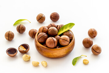 Shelled macadamia nuts in bowl with green leaves. Protein food