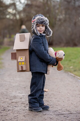 Little child, blond boy with pet dog, carying home on his back, kid, having paper house