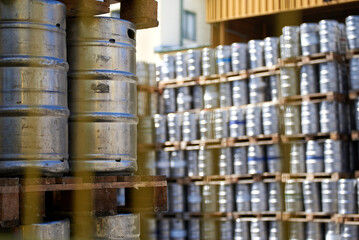 Kegs of beer piled in brewery warehouse.