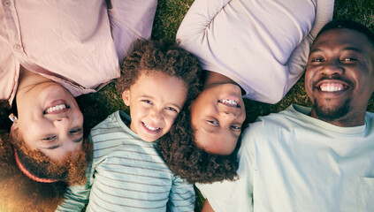 Smile, black family lying on grass from above and happy face of mom, dad and children together....