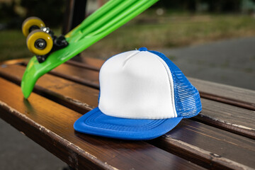 Trucker cap, snapback, blue with white front, blue mesh, firm. In location on playground. Mock-up for branding