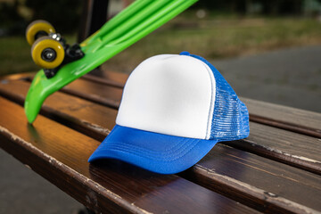 Trucker cap, snapback, blue with white front, blue mesh. In location on playground. Mock-up for branding