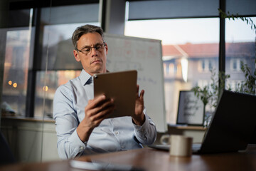 Portrait of businessman in office. Man using digital tablet. Businessman having video call