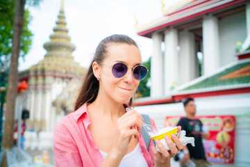 Woman enjoy eat street food ice cream travel in buddha temple