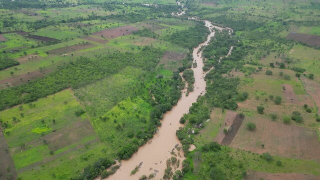 Muddy river running through rural villages and providing people necessary water for agriculture. Tanzania, Africa