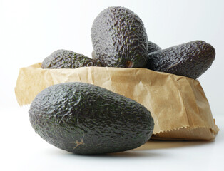 Tropical fruit, avocado on white background and kraft paper bag