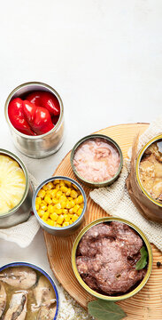 Canned vegetables, beans, fish and fruits in tin cans on a white background. Food stocks.