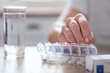 Too much poison come undone. Cropped shot of an unrecognizable elderly man arranging his medication at the table at home.