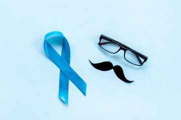 Blue ribbon prostate cancer and glasses with mustache. Mans health concept
