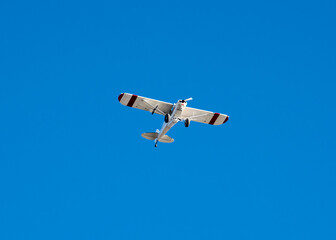 Lookup up a small airplane light aircraft under sunny clear blue sky near seaplane base in...