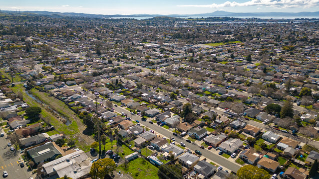 Aerial photos over a community in Vallejo, California with houses, streets, cars and parks on a sunny day in March.