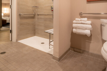 Wheelchair accessible hotel bathroom shower with tile floor and walls. - obrazy, fototapety, plakaty
