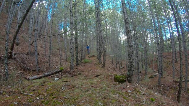 Man Unicyclist In Forest Ending With Progressive Slow Motion. Passing In Front Of The Camera