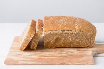 Sliced loaf of white sourdough bread on light background, healthy eating