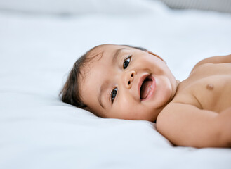 Im handing out smiles today, you want one. Shot of an adorable baby girl lying on a bed.