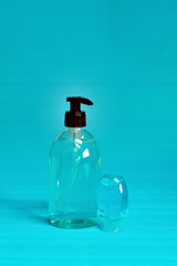 Plastic bottle of the blue transparent liquid soap and a pocket antiseptic gel isolated over the blue background 