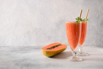 Papaya lassi or smoothie on gray background. Freshness cold beverage made of yogurt, water, spices,...