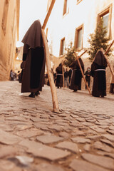 Penitents by day carrying a cross on their shoulders