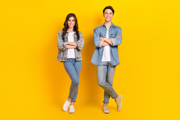 Full body photo of two cheerful friendly partners folded hands posing isolated on yellow color background