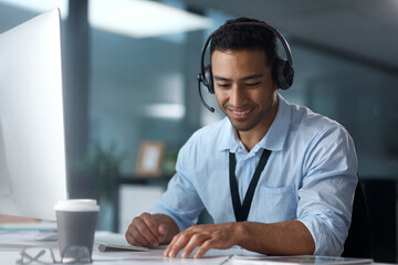 If you need anything else, Im your guy. Shot of a young man using a headset and computer in a modern office.